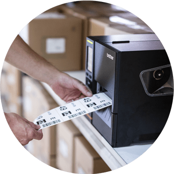 Brother black label machine printing label with barcode, hand holding labels