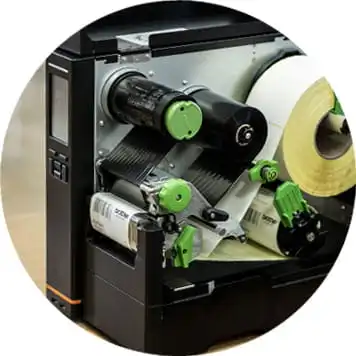 Machine open, white roll of labels, green mechanisms, rollers
