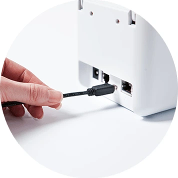 Cable being plugged into the back of Brother TD-2 desktop printer
