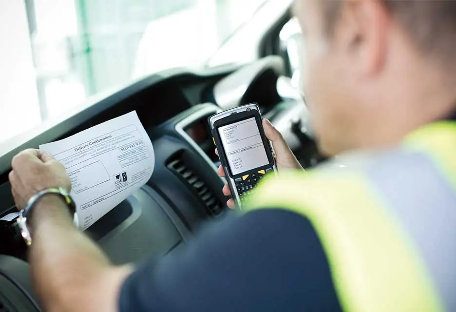 Man wearing hi-vis in vehicle printing document
