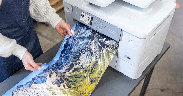 Large format paper of lanscape on gloss paper being printed from printer
